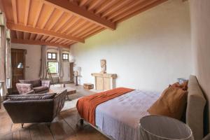 a bedroom with a bed and a couch and a chair at Château beyrin 