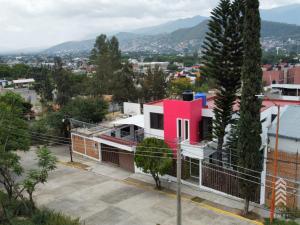 een roze huis in een straat in een stad bij Casa Embi Oaxaca in Oaxaca City