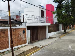een rood-wit gebouw op een straat bij Casa Embi Oaxaca in Oaxaca City
