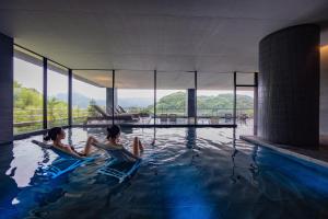 dos personas sentadas en una piscina en Urari Takeo Garden Terrace Spa Resorts, en Takeo