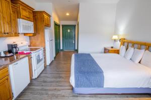 a bedroom with a large bed and a kitchen at Teton Valley Motel in Victor