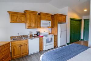a kitchen with wooden cabinets and white appliances at Teton Valley Motel in Victor