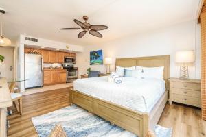 Un dormitorio con una cama grande y una cocina. en Royal Kahana 702 Studio Condo, en Kahana