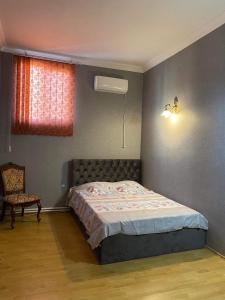 1 dormitorio con 1 cama, 1 silla y 1 ventana en Guesthouse David, en Mtskheta