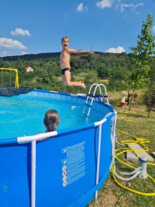 un hombre saltando a una piscina en un tobogán de agua en Meriland Kosmaj, en Nemenikuće