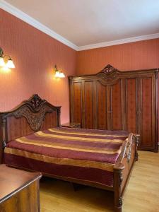 1 dormitorio con 1 cama grande y muebles de madera en Guesthouse David, en Mtskheta