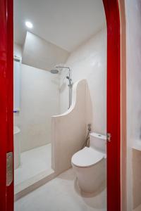 a white bathroom with a toilet and a shower at Happiness Hotel in Quy Nhon
