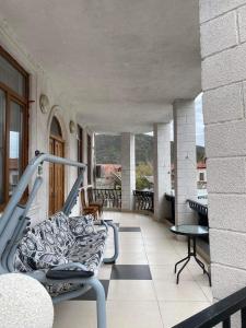 a balcony with a couch and a table and chairs at Guesthouse David in Mtskheta