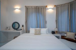 a bedroom with a large white bed with blue curtains at Happiness Hotel in Quy Nhon