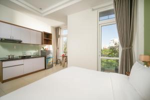 a bedroom with a large bed and a large window at Tashi Park View Hotel & Apartment in Danang