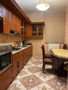 una cocina con armarios de madera y una mesa. en Guesthouse David, en Mtskheta