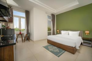 a bedroom with a large white bed and a television at Tashi Park View Hotel & Apartment in Danang