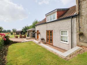a house with a garden and a patio at The Barn in Northallerton