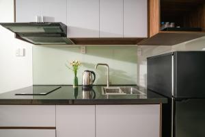 a kitchen with a sink and a refrigerator at Tashi Park View Hotel & Apartment in Da Nang