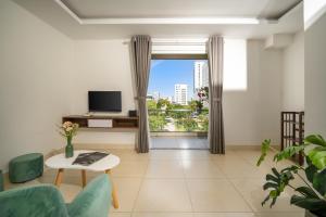 a living room with a large window and a tv at Tashi Park View Hotel & Apartment in Da Nang