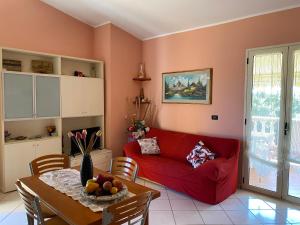 a living room with a red couch and a table at Residenza il sole isola Capo Rizzuto in Isola Capo Rizzuto