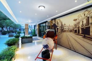 a wall mural of a city with a carriage and an umbrella at Hangzhou Lanshe hotel in Hangzhou