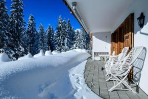 a patio with chairs and a table in the snow at Chesigna 2 in Arosa