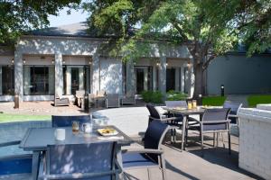 eine Terrasse mit Tischen und Stühlen vor einem Gebäude in der Unterkunft Courtyard by Marriott Dallas Plano Parkway at Preston Road in Plano