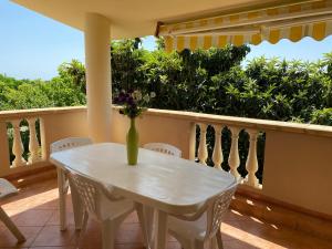 un jarrón de flores sentado en una mesa en un balcón en Residenza il sole isola Capo Rizzuto, en Isola di Capo Rizzuto