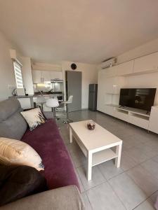 a living room with a couch and a table at Le Castello in Saint-Aygulf