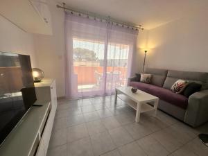 a living room with a couch and a table at Le Castello in Saint-Aygulf