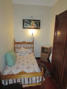 1 dormitorio con cama de madera y TV en Casa Els Grecs, en Roses