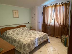 a bedroom with a bed and a window with curtains at Residenza il sole isola Capo Rizzuto in Isola Capo Rizzuto