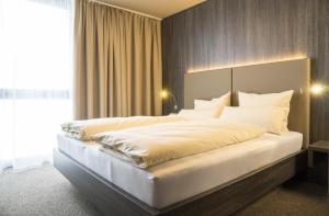 Een bed of bedden in een kamer bij MYHOTEL München Olching