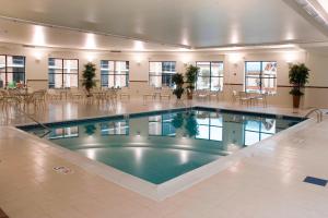 a large pool in a building with tables and chairs at Courtyard by Marriott Canton in North Canton