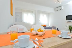 uma mesa de jantar com sumo de laranja e comida em Apartment Stipić em Zadar