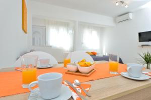 a dining room table with orange juice and food on it at Apartment Stipić in Zadar