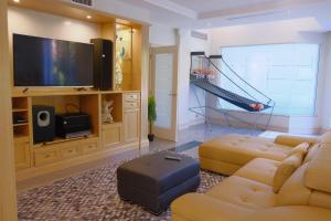 uma sala de estar com um sofá e uma televisão de ecrã plano em Kellyville Luxury 5 Br House Quiet & Spacious em Kellyville