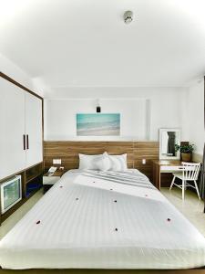 コンダオにあるTuấn Ninh Hotel Iのベッドルーム(白い大型ベッド1台、デスク付)