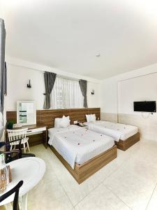 a hotel room with two beds and a television at Tuấn Ninh Hotel I in Con Dao