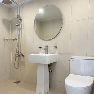 a bathroom with a sink and a toilet and a mirror at Rooftop Moonlight Pension in Gangneung +22 photos