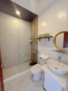 a bathroom with a toilet and a sink and a shower at Anlio Resort in Dauis
