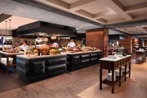 a restaurant with chefs preparing food in a kitchen at Bangkok Marriott Marquis Queens Park in Bangkok