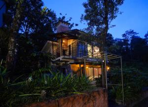 a house in the middle of a forest at night at Safari Hills in Vayittiri