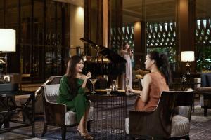 two women sitting in chairs in a restaurant at Bangkok Marriott Marquis Queens Park in Bangkok