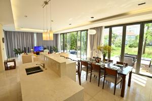 a dining room and living room with a table and chairs at Pool Villas at Danang Beach with Private Pool in Da Nang