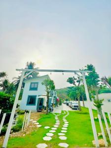a walkway over a yard with a house at 24 Gold Homestay in Phan Thiet