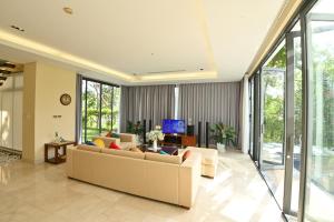 a living room with a couch and a tv at Pool Villas at Danang Beach with Private Pool in Danang