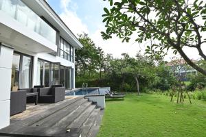a house with a wooden deck and a yard at Pool Villas at Danang Beach with Private Pool in Danang