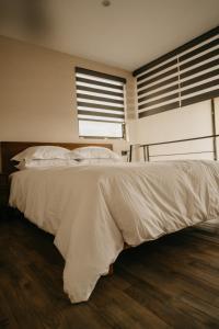 een bed met witte lakens en kussens in een slaapkamer bij Mineral del Cielo in Mineral de Pozos