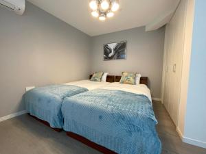 a bedroom with a bed with a blue blanket at Bonheur Akasaka in Tokyo