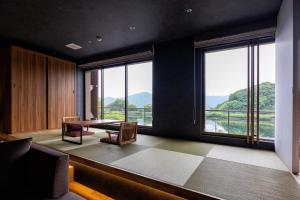 a dining room with a table and large windows at Urari Takeo Garden Terrace Spa Resorts in Takeo