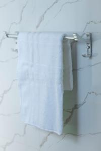 a white towel hanging on a towel rack in a bathroom at Acacia Stay in Lilongwe