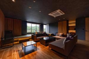 a living room with a couch and a tv at Urari Takeo Garden Terrace Spa Resorts in Takeo