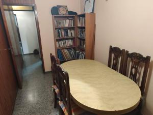 una mesa y sillas en una habitación con estantería. en Departamento Funcional en Guaymallén